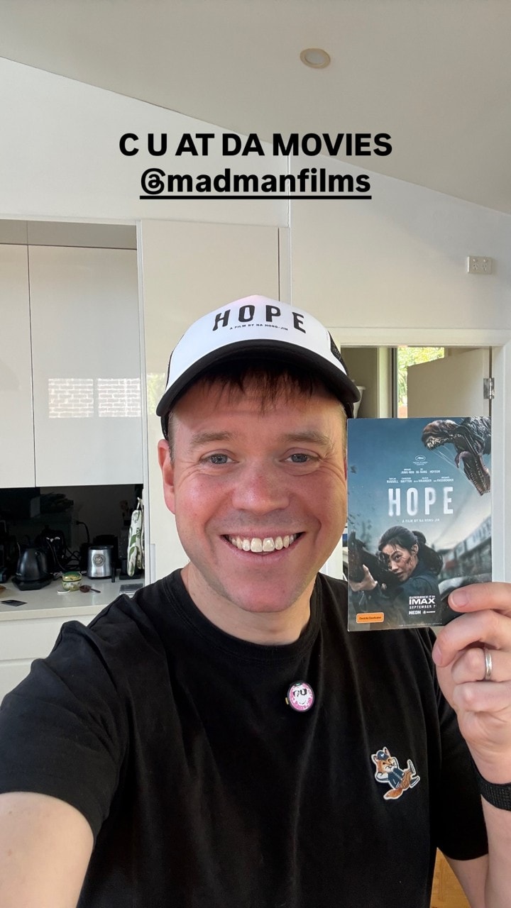 Andrew Levins wearing his HOPE cap and holding the cinema invitation