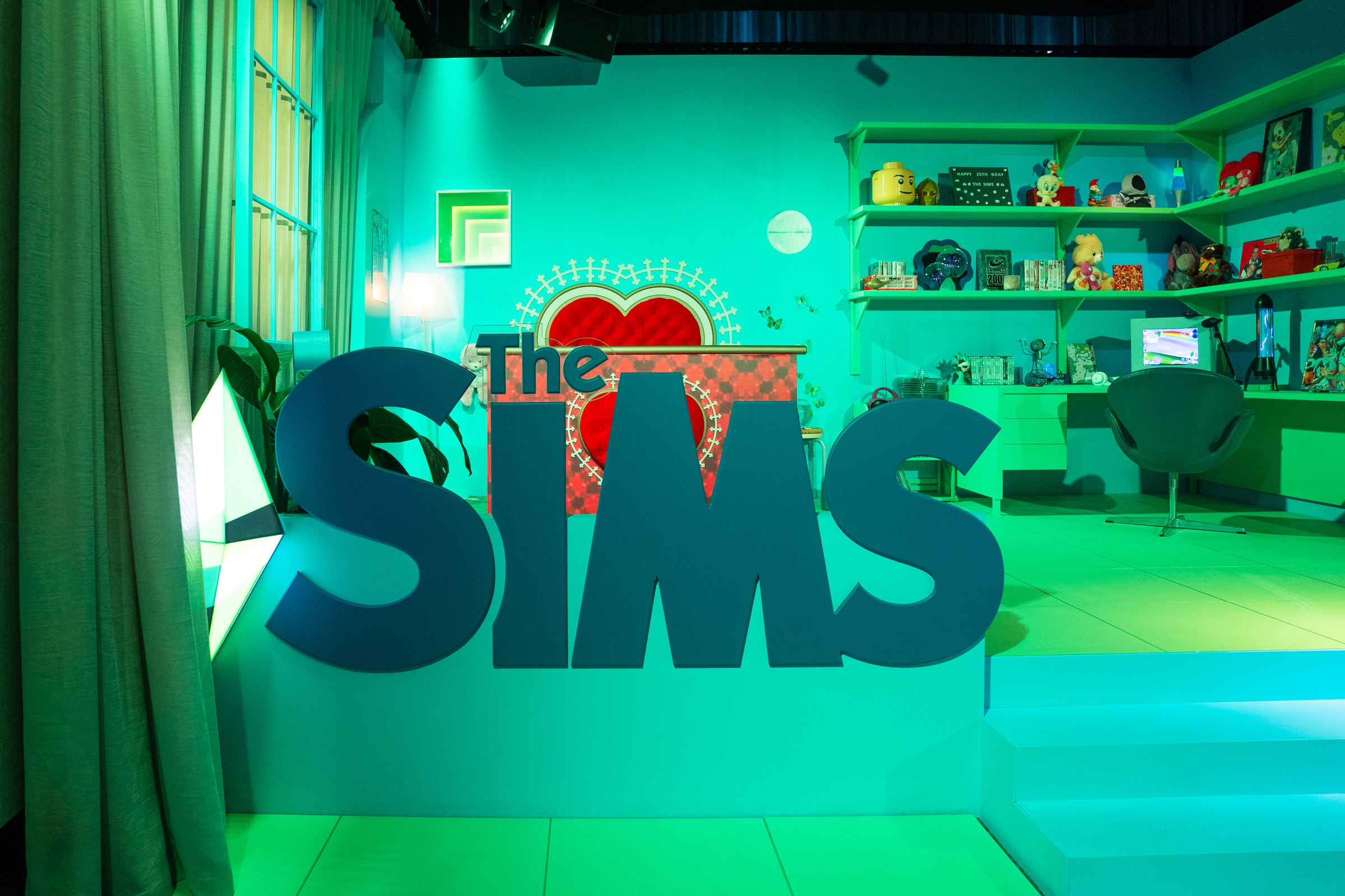 The Sims 25th birthday pop-up at ACMI: a giant Sims logo in front of a Y2K-style bedroom set